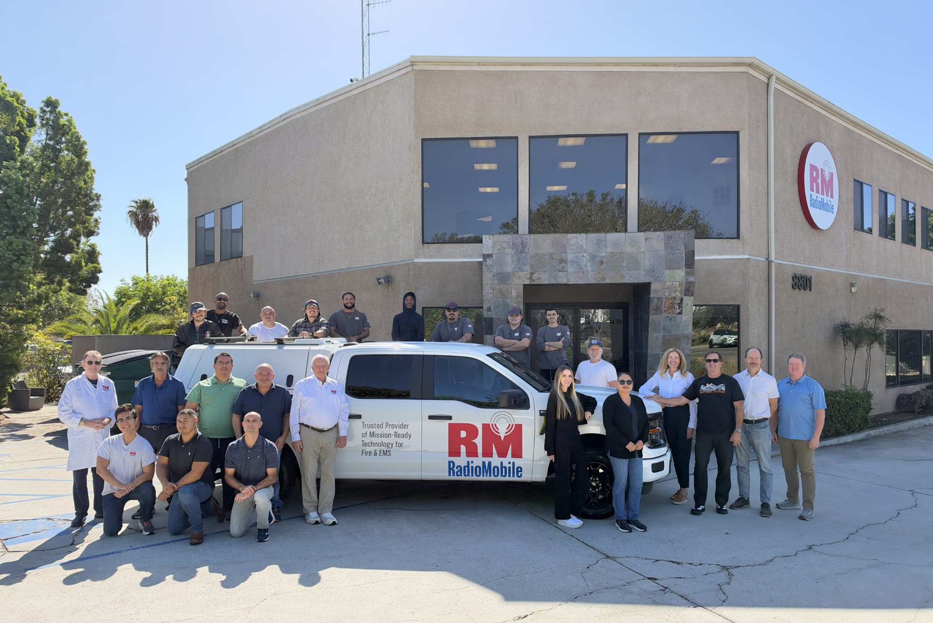 RadioMobile team gathered outside the RadioMobile facility with a branded service vehicle.